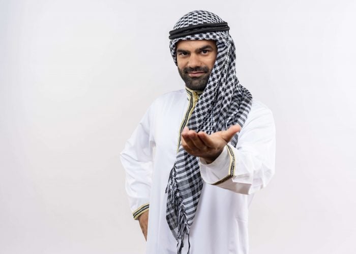 Man in muslim garnments using Arabic greetings to say goodbye