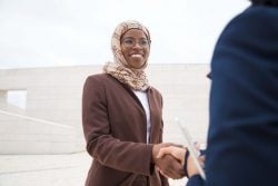 Business woman using an arabic greeeting with a colleague