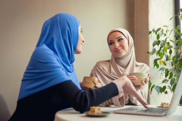 Two women in muslim garments chatting