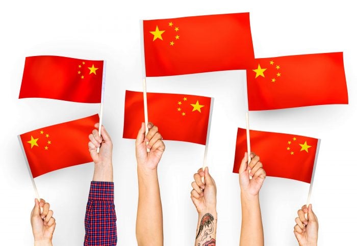Hands waving Chinese flags