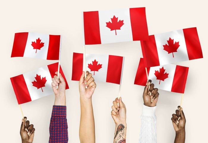 Hands waving the Canadian flag to exemplify how important it is to learn French in Canada to communicate with everyone