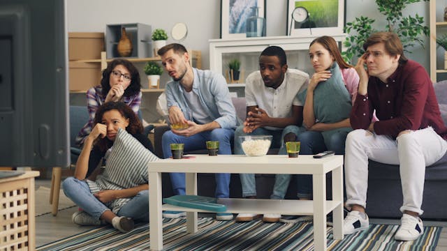 A group of friends watching a film at home