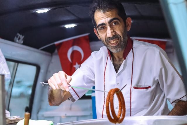Turkish street food vendor serving simit at a local food stall.