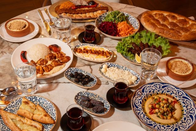 Traditional Turkish meal with kebabs, meze, pide, hummus, and Turkish tea.