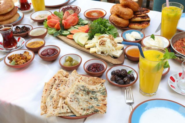 Traditional Turkish breakfast spread with bread, cheese, olives, tea, and fresh vegetables.